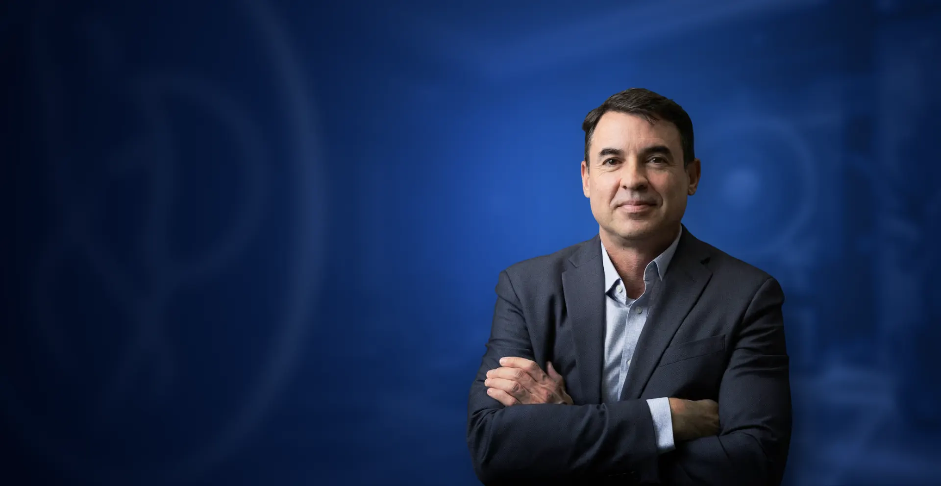 Dr. Edson Prata Jr., cirurgião plástico, de terno e braços cruzados